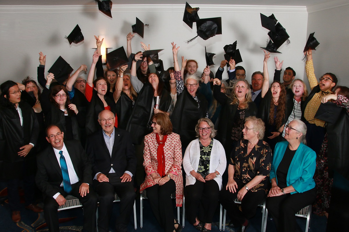 Graduates throw their caps in the air.