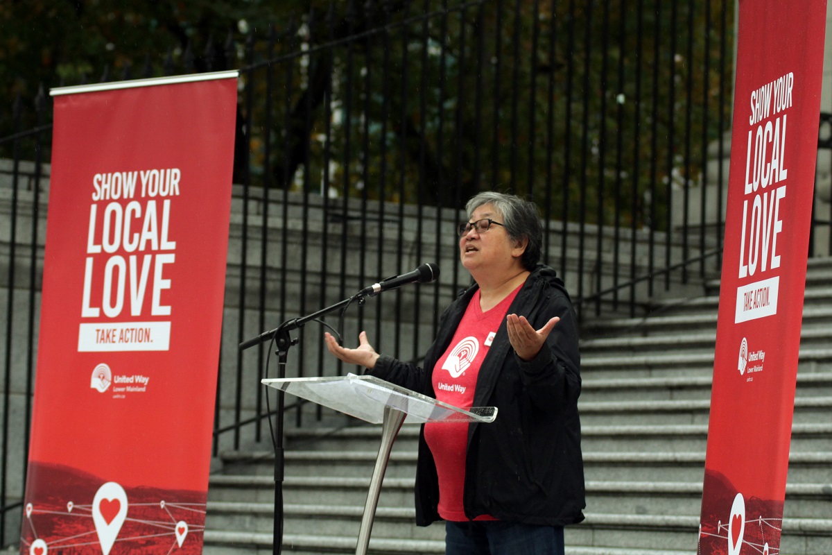 A woman stands behind a podium and delivers a speech.