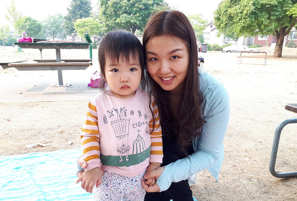 A women and her child smile at the camera.