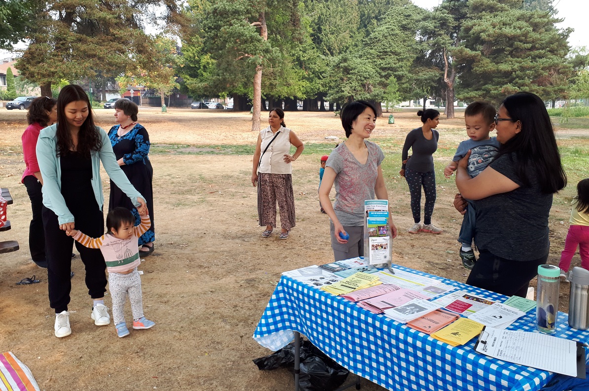 A group of parents and children in a park.