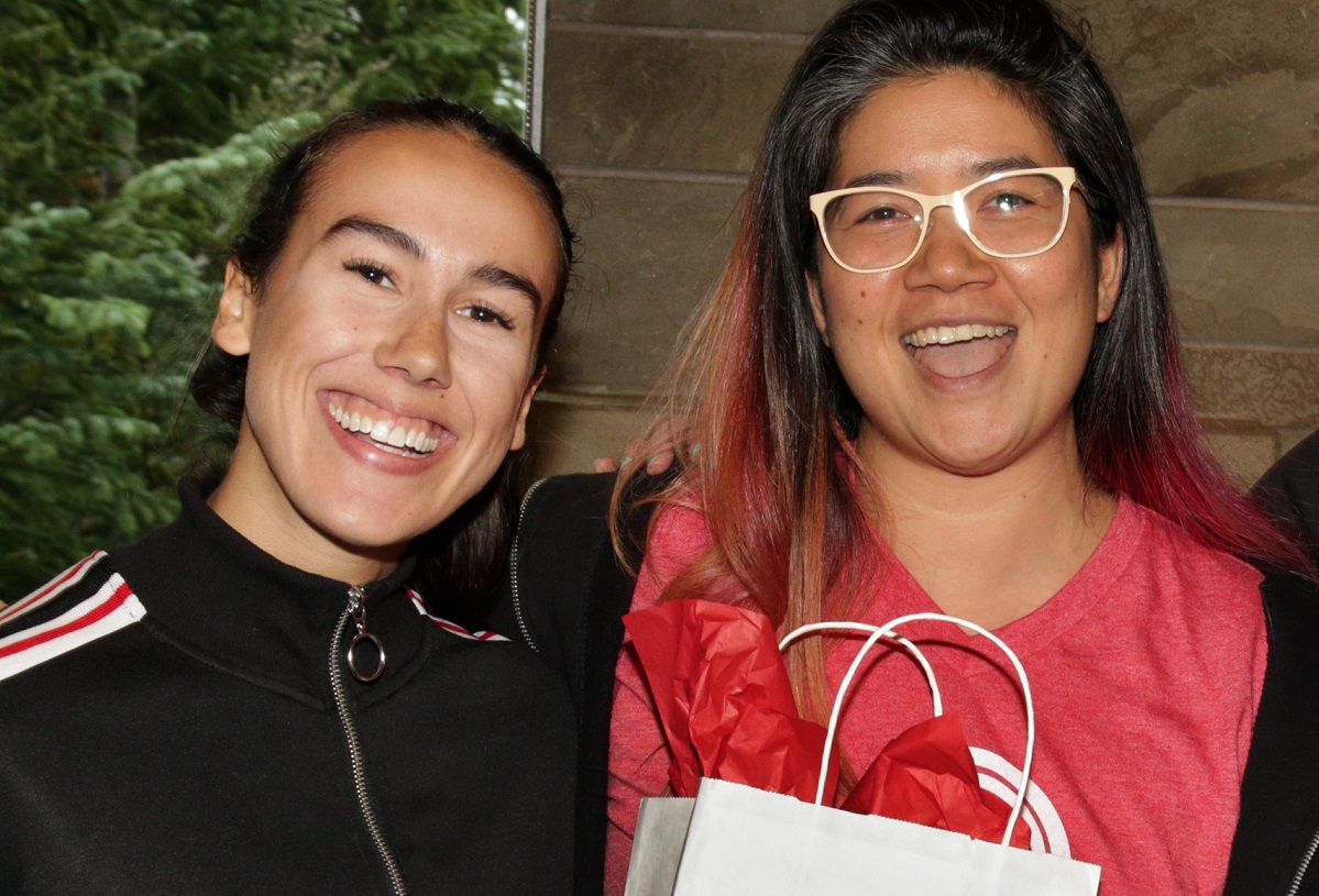 Two women smile at the camera.