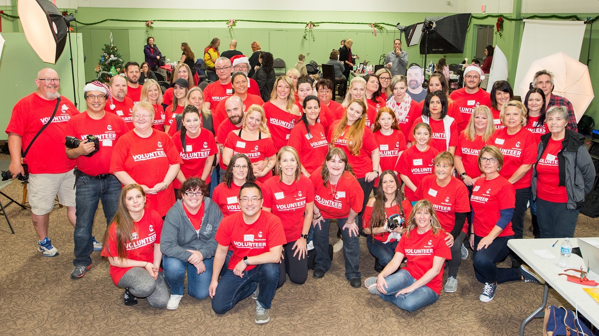 A group of people wearing red shirts smile at the camera.