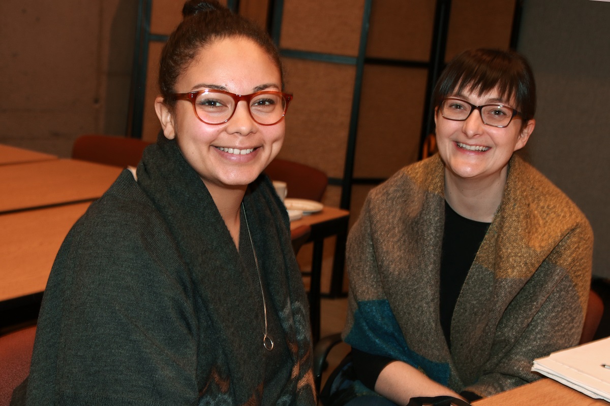 Two women smile at the camera.