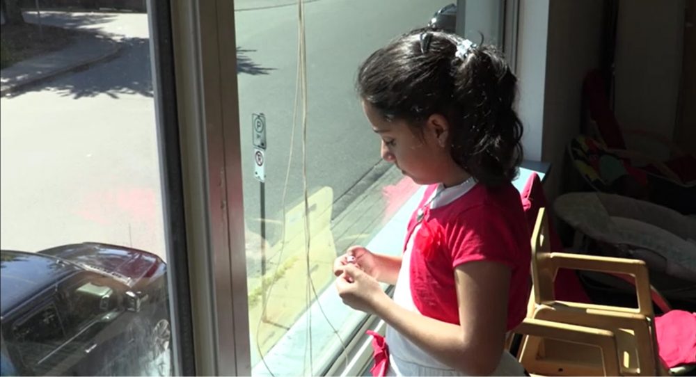 Reema standing at a window