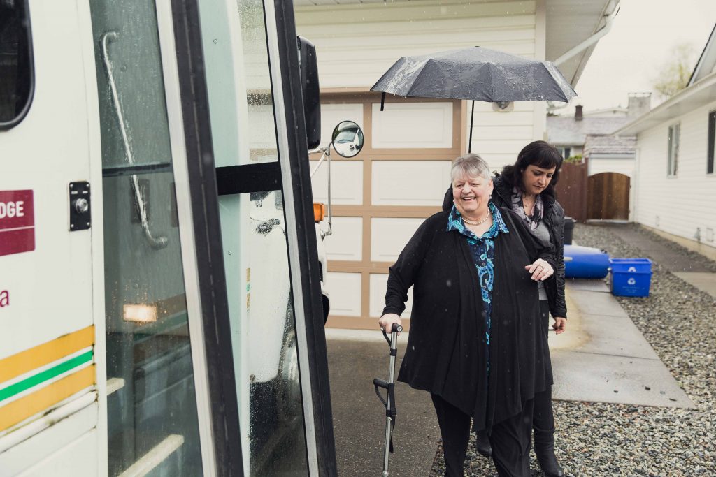senior angie gets help into a bus